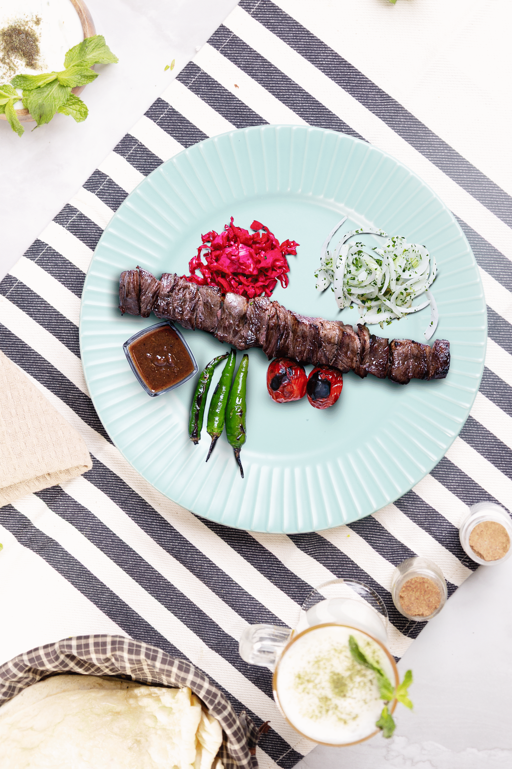 Grilled lamb kebabs served on a traditional platter at Layali Al Rabee, the Best Iranian Restaurant in Abu Dhabi.
