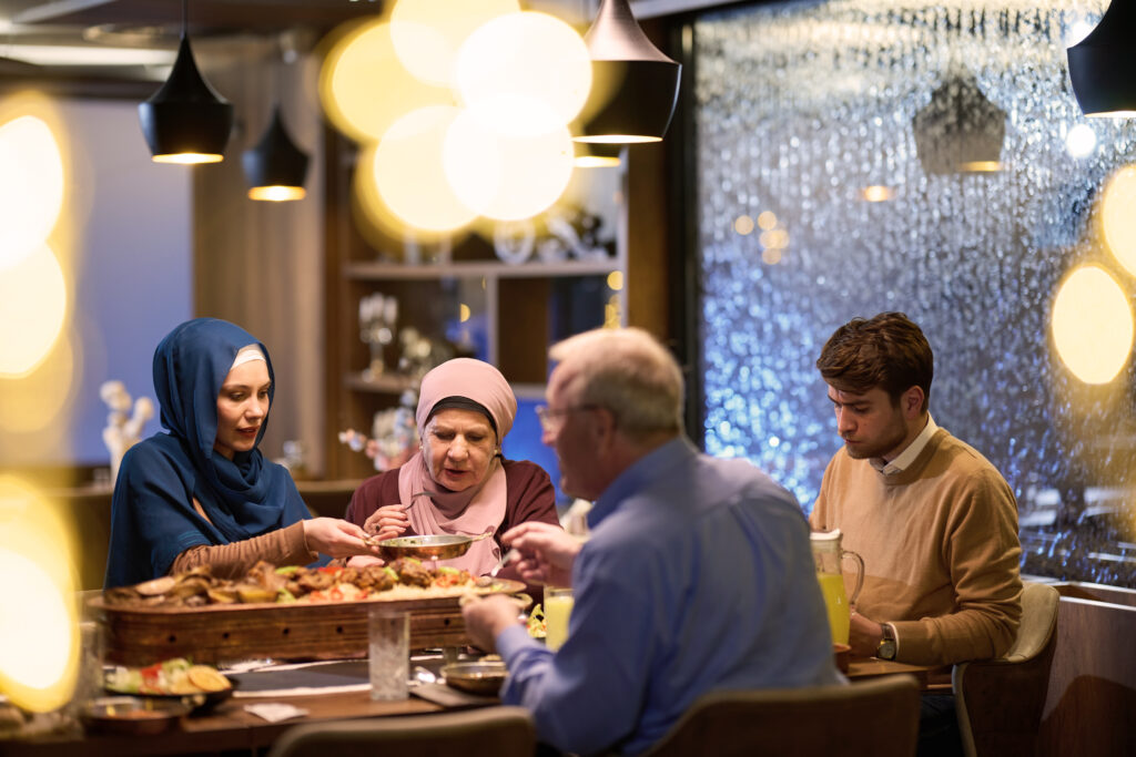 A family enjoying a traditional Iranian dinner with assorted kebabs and rice at Layali Al Rabee, the Best Iranian Restaurant in Abu Dhabi.